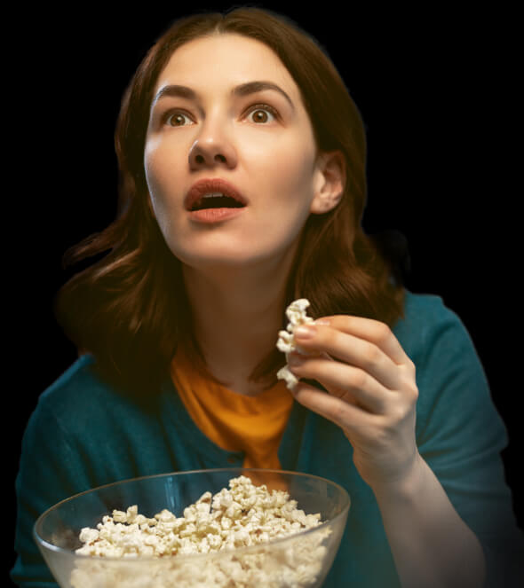 ポップコーンを食べながら映画鑑賞する女性イメージ