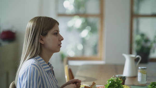 カラーグレーディングの比較画像 女性がダイニングテーブルについている、コントラストが明るく調整されている