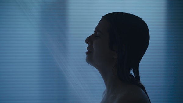 カラーグレーディングの比較画像 女性の悲しそうな横顔、シアンの調整で青みがかりサスペンス感を演出している