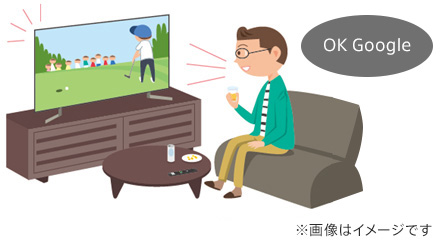 リビングでテレビに向かって「 OK Google 」と話しかけている画像