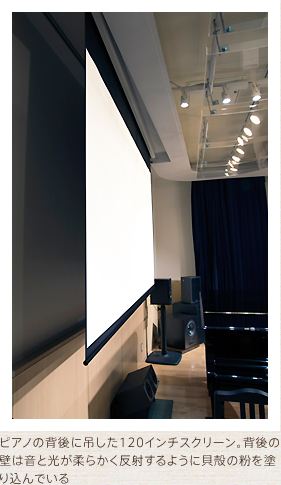 ピアノの背後に吊した120インチスクリーン。背後の壁は音と光が柔らかく反射するように貝殻の粉を塗り込んでいる